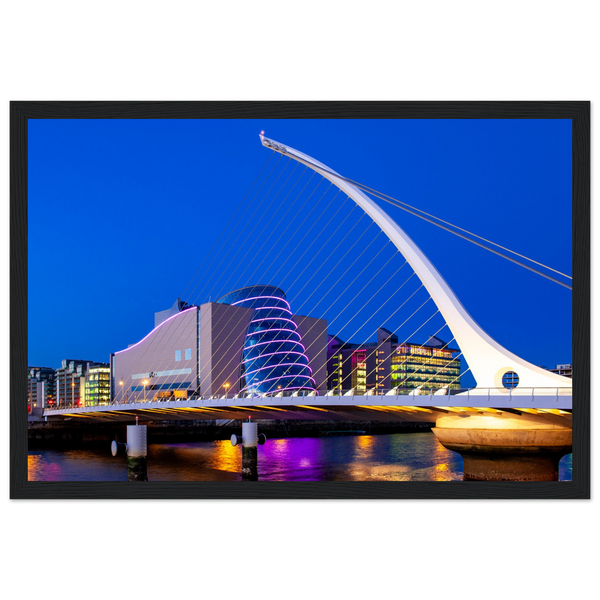 Framed art print featuring Dublin's illuminated Samuel Beckett Bridge and Convention Centre at night. Lights reflect on the River Liffey, capturing Dublin's magical skyline. Ideal for adding a touch of Irish charm to any room.