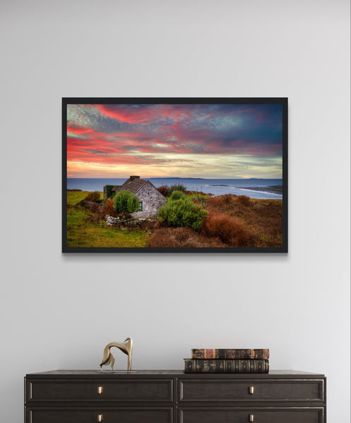 Art print capturing a serene sunset over the Atlantic Ocean in Doolin, Co. Clare, Ireland. A small cottage stands in the foreground, blending with the colorful sky reflecting on the water.