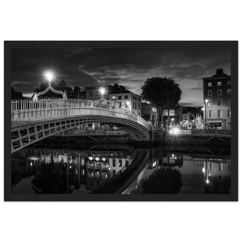 Black and white framed wall art print of Dublin's iconic Ha'penny Bridge at night. The detailed photograph captures the bridge's intricate architecture and its reflection in the River Liffey, creating a timeless and elegant piece perfect for home or office decor