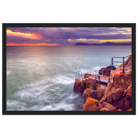 Framed wall art print featuring the serene Vico Baths in Dalkey, Dublin. The artwork showcases clear blue waters, natural rock formations, and the picturesque coastline, capturing the peaceful beauty of this iconic Irish swimming spot. Ideal for home decor.