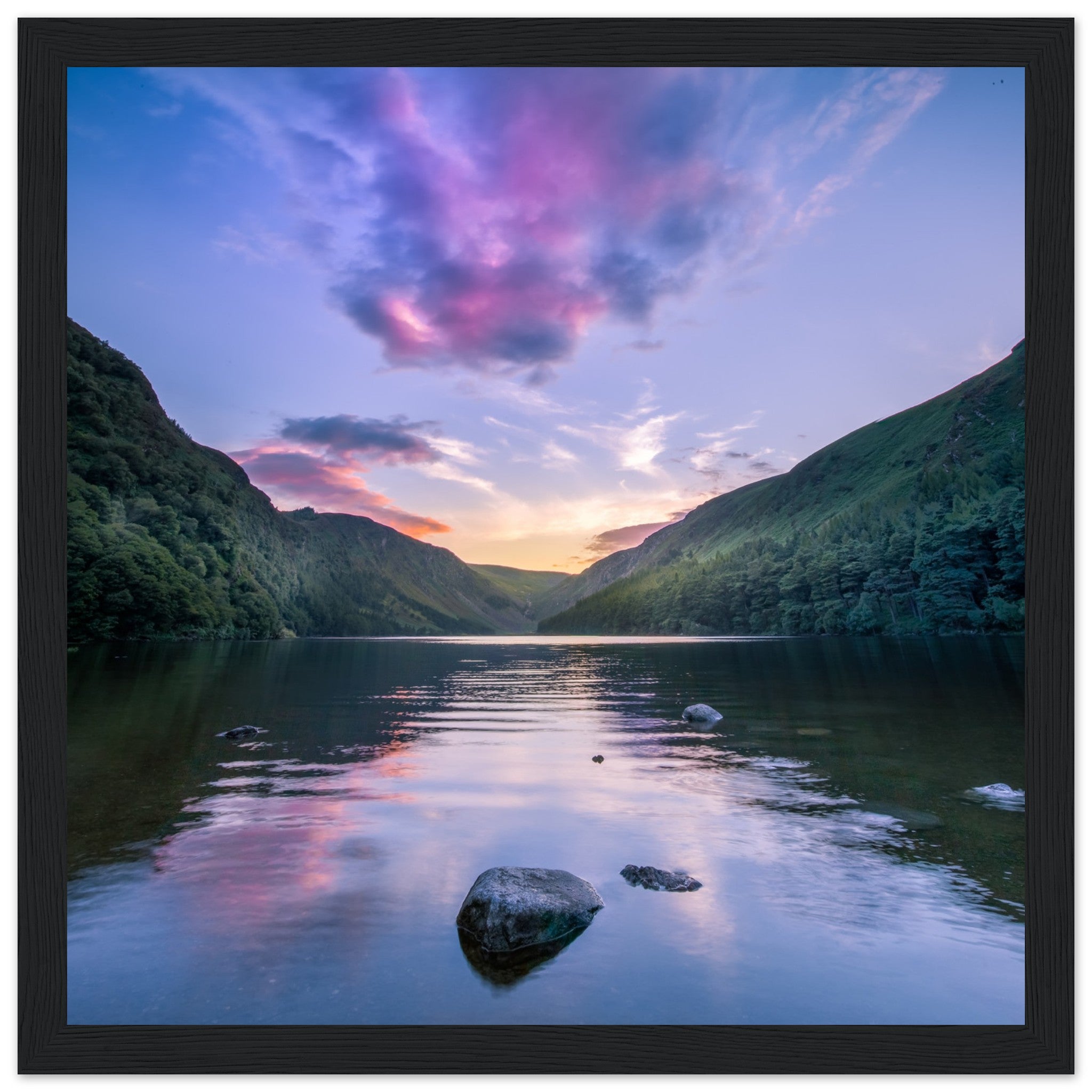 Framed wall art print of Glendalough's Upper Lake at dusk in Co. Wicklow. Features a serene reflection of the sky in calm waters, surrounded by lush green landscape. Perfect for nature lovers and adding a touch of Irish tranquility to any space.