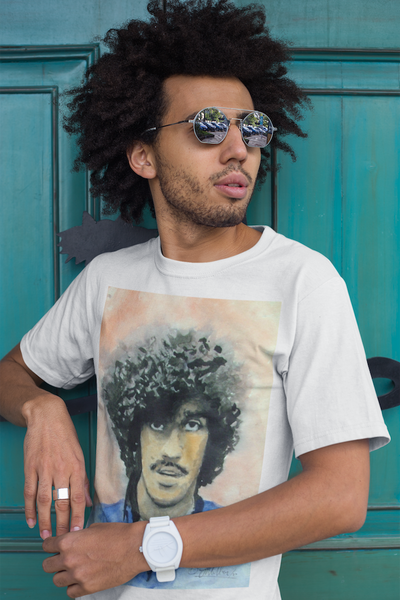 man with an afro wearing Phil Lynott tribute T-shirt: Black, featuring iconic Thin Lizzy frontman graphic. Comfortable, durable fabric, perfect for rock music lovers and fans. Ideal gift or unique wardrobe addition. Celebrate Irish rock heritage and Phil Lynott's legendary style.